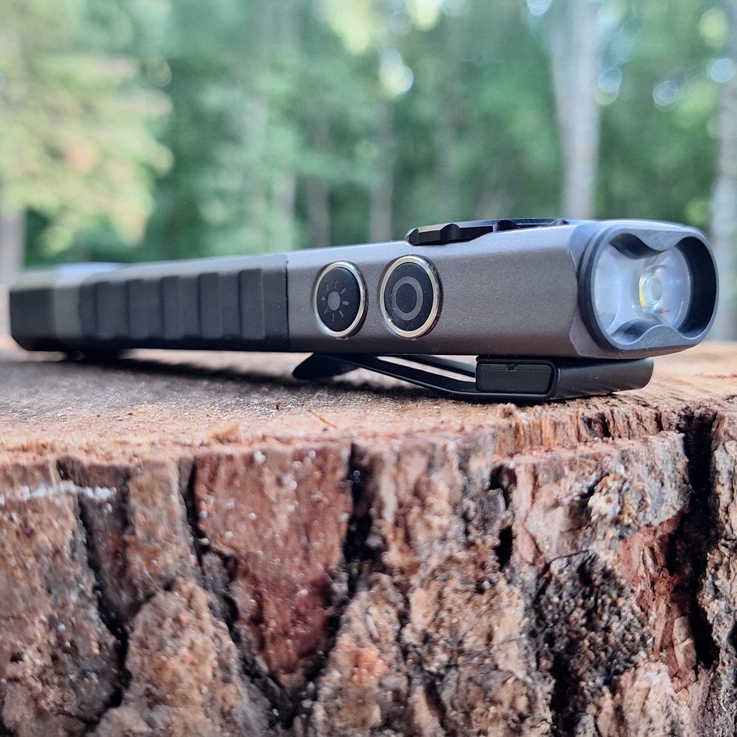 LP-EDC+ 8.0 Low Profile Everyday Carry Ultra-Thin Flashlight laying down posing on a stump